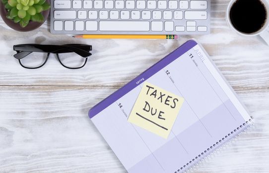 Tax concept with calendar reminder, and other desktop work supplies.