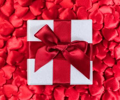 Valentines gift box with red hearts in background 