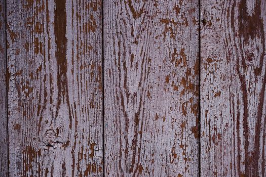 Old red wooden texured door surface closeup. Relief on surface. Stock photo of old wooden door pattern of aged boards with scratches. Red and gray colors on photo.