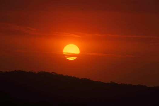 Large golden sun setting amidst cloud and smoke haze from bushfires