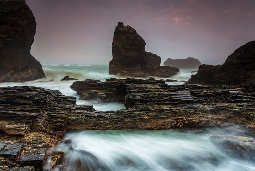 Raging waters tumble over jagged rocks and forged through eroded rock bridges.  The smell of salt fills the nostrils  and a fine sea mist is ever present and quietly wafts and caresses everything around here.  There is a light smoke haze as well from a bushfire further north, The amount of smoke and mist varied throught the morning but the large waves were consistent