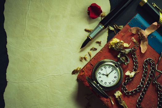 Vintage pocket watch and brass pen on old book. At 8 o’clock in morning. Top view and copy space. Education and vintage style concept.