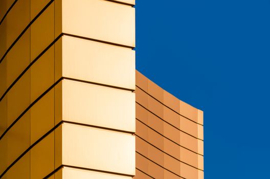 architectural abstract pattern fragment of a wall of a yellow modern building on a blue background