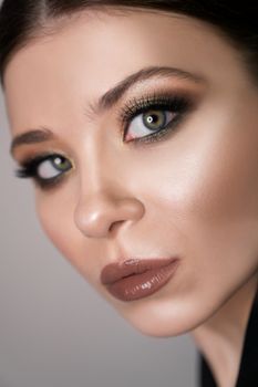 Close up portrait of girl with perfect emerald makeup. Long eyelashes. Lady looking to the camera. Beauty and cosmetics concept