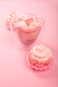 Valentine day love cupcake decorated with cream and hot chocolate on pink background with copy space for text