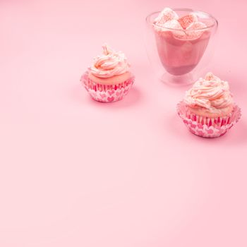 Valentine day love cupcake decorated with cream and hot chocolate on pink background with copy space for text