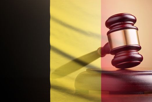 Lawyers wooden gavel resting on its plinth over the flag of Belgium in a concept of the courts, legality and law and order