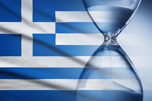 Hourglass with running sand over the flag of the Greece in a concept of urgency, countdown , deadlines and time management