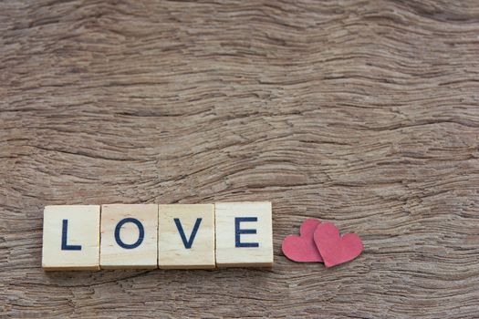 Text wooden blocks spelling the word love on wooden background