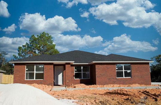 New brick home construction with a pile of sand in front