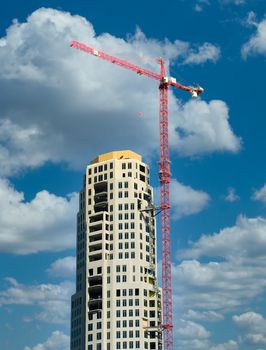 A high rise construction project with a red crane on top