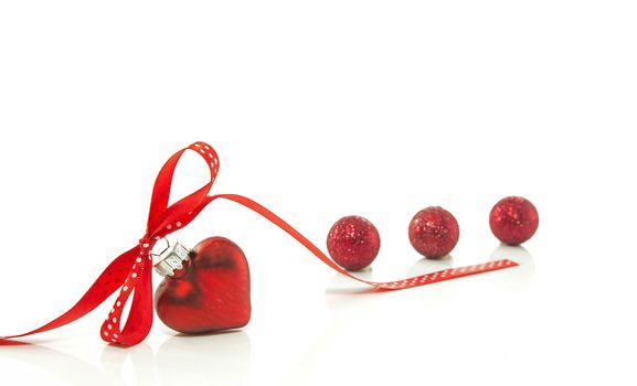 red heart for Christmas with a bow of a red ribbon isolated on white ribbon
