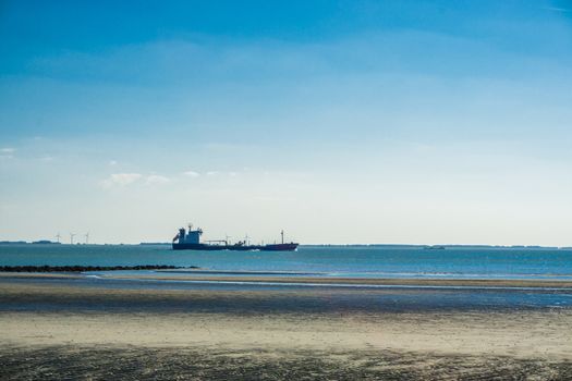 beach landscape with a boat sailing on sea