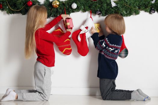 Adorable little children open their stocking gifts on Christmas morning