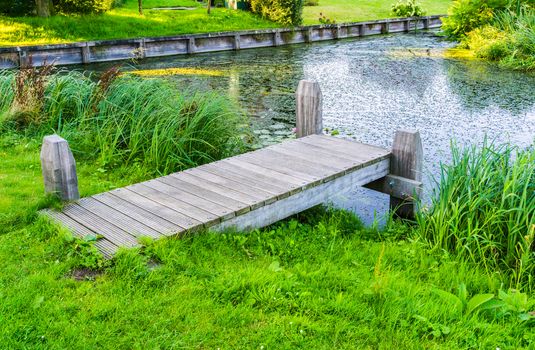 wooden pier bridge at the park pond