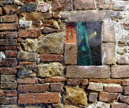 Halloween stone brick wall covered in spider web rags with a window looking on a scary horror forest with cabin and ghost witch