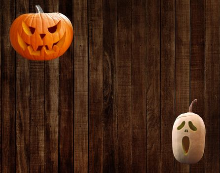 Carved halloween pumpkins on a wall with wooden planks background