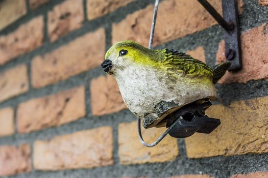 Fake Robin bird garden decoration sculpture on the brick wall