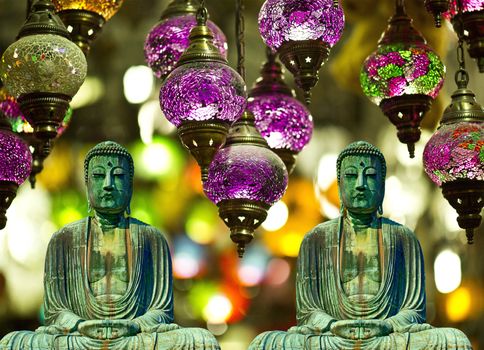 two buddhist statues meditating with lamps and background buddhism card