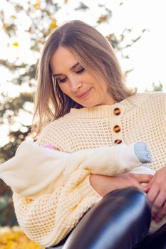 Portrait of a young girl holding a baby while walking in a park