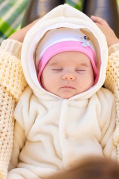 On the mother's lap lies and sleeps two-month-old baby