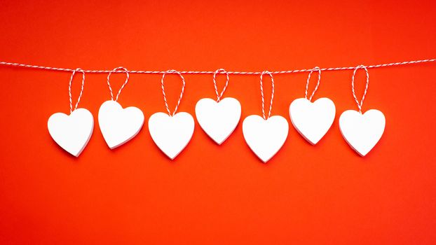 White wooden hearts on a red background. Blank for the designer.Valentine's Day.