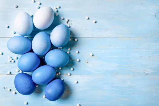 Easter concept. Ombre eggs in blue colors on blue wooden background with copy space for text. Top down view or flat lay. Classic blue colors in Easter 2020