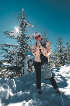 Happy adult woman posing with blue sky and the sun n the background.