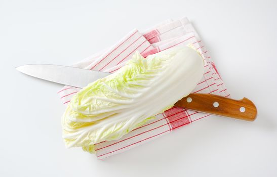 Fresh Chinese cabbage and kitchen knife on dish towel