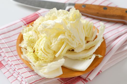 Fresh Chinese cabbage leaves on wooden plate