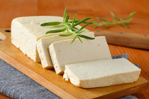 Sliced block of fresh bean curd (tofu) on cutting board