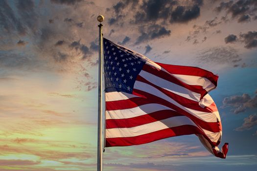 An American Flag blowing in the wind with sky background