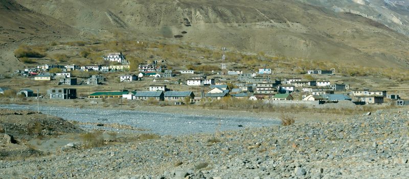 Village at Foothill of Himalayas. Small Villages In The Foothills Of Himalayan picturesque valley. A beautiful indian landscape of a town city at foothills of snow capped Mountain ranges. Kaza India