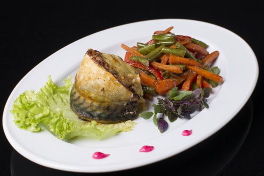 Food on a plate. Fried meat, Korean carrots, seasoning, mayonnaise, sauce, lettuce leaf and dill.Fish on a plate. Cooked mackerel