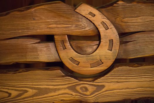 On wooden boards carved wooden horseshoe.Symbol of luck. Texture of a tree. Horseshoe. Textured board