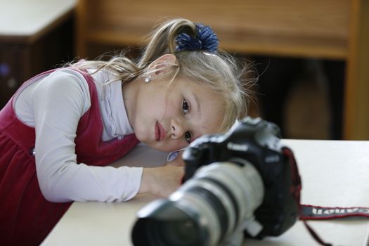 .Little girl looks at the camera images.To photograph children. Child photographer. Curious girl.Children and the camera