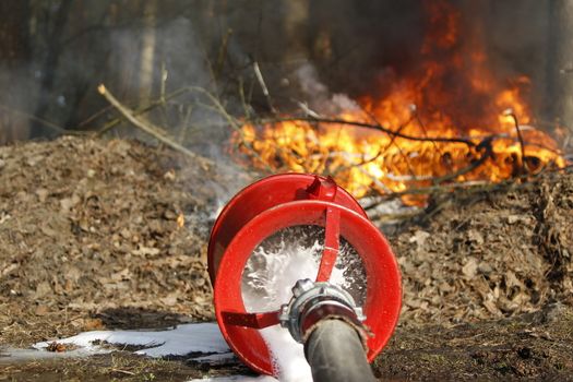 The fireman's hand holds a fire hose to extinguish a fire.Extinguish the fire. Fire hose