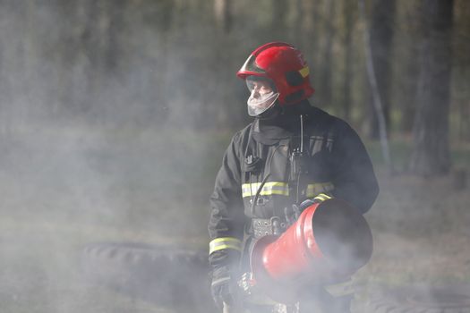 Firefighter in smoke when extinguishing forest fire.Extinguish the fire. Work firefighter. Fight with fire. Dangerous profession