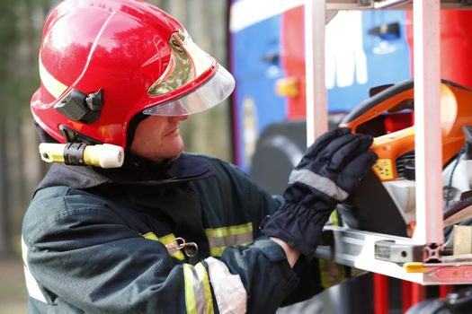 Firefighter retrieves fire hoses.The brave firefighter. Work of firefighter