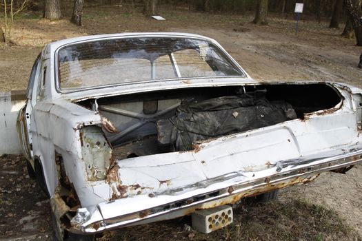 An old, rusty, rotten machine.Rusty machine. Pollution of the forest. Old rotten machine. Car body.