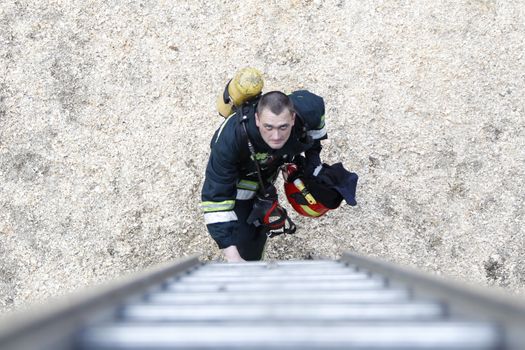 .Fireman will climb up the stairs.Work firefighter. Extinguish the fire. Rescue work. Exercises of rescuers.