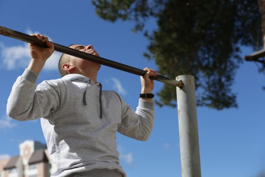 Exercises on the crossbar.Physical culture lesson. A young gymnast. Sports training of soldiers