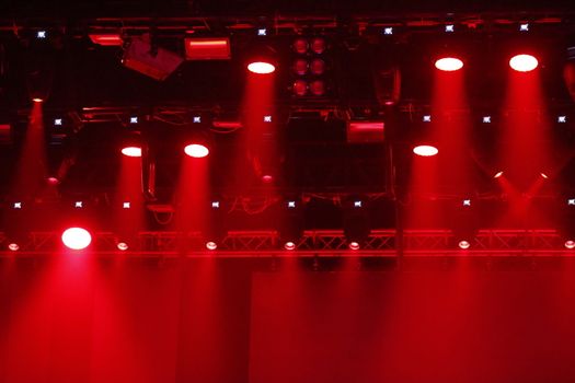 Concert spotlights.Red and white rays of powerful projectors on stage