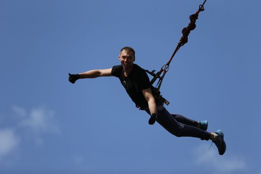 Jumping with a rope.The extreme guy jumped from a huge height.Ropejumping.