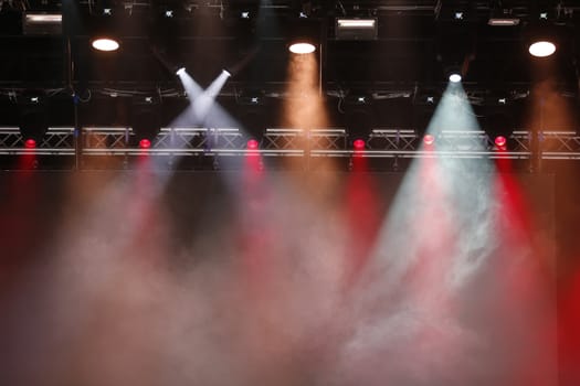 Concert spotlights.Concert spotlights.Red and white rays of powerful projectors on stage