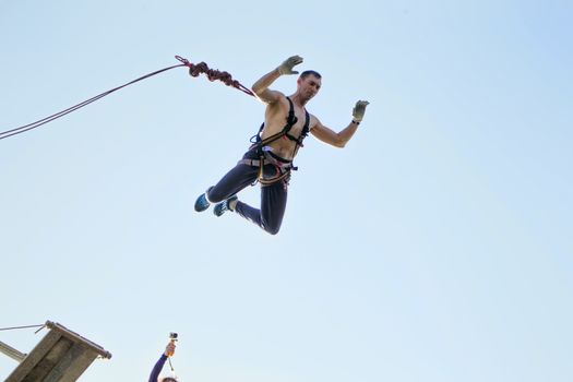 Jumping with a rope.The extreme guy jumped from a huge height.Ropejumping.