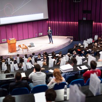 Speaker Giving a Talk at Business Meeting. Audience in the conference hall. Business and Entrepreneurship concept.