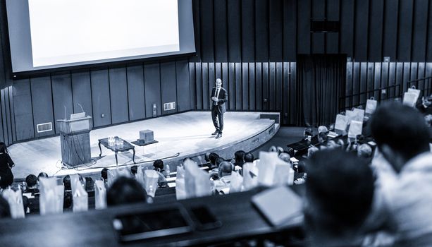 Speaker Giving a Talk at Business Meeting. Audience in the conference hall. Business and Entrepreneurship concept.