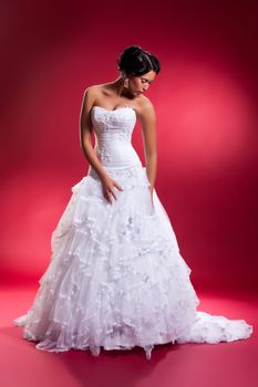 Young beautiful woman in a wedding dress on a studio background
