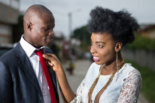 Smiling young woman arranging her boyfriend's tie.